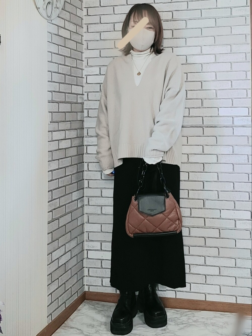 ベージュ系のブルゾン、ホワイト系のTシャツ/カットソー、ベージュ系のニット/セーターを着用したレディースの冬コーディネートの2枚目の写真