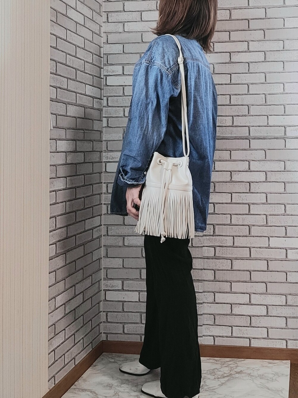 ブルー系のシャツ/ブラウス、ホワイト系のタンクトップ、ホワイト系のショルダーバッグを着用したレディースの秋コーディネートの2枚目の写真