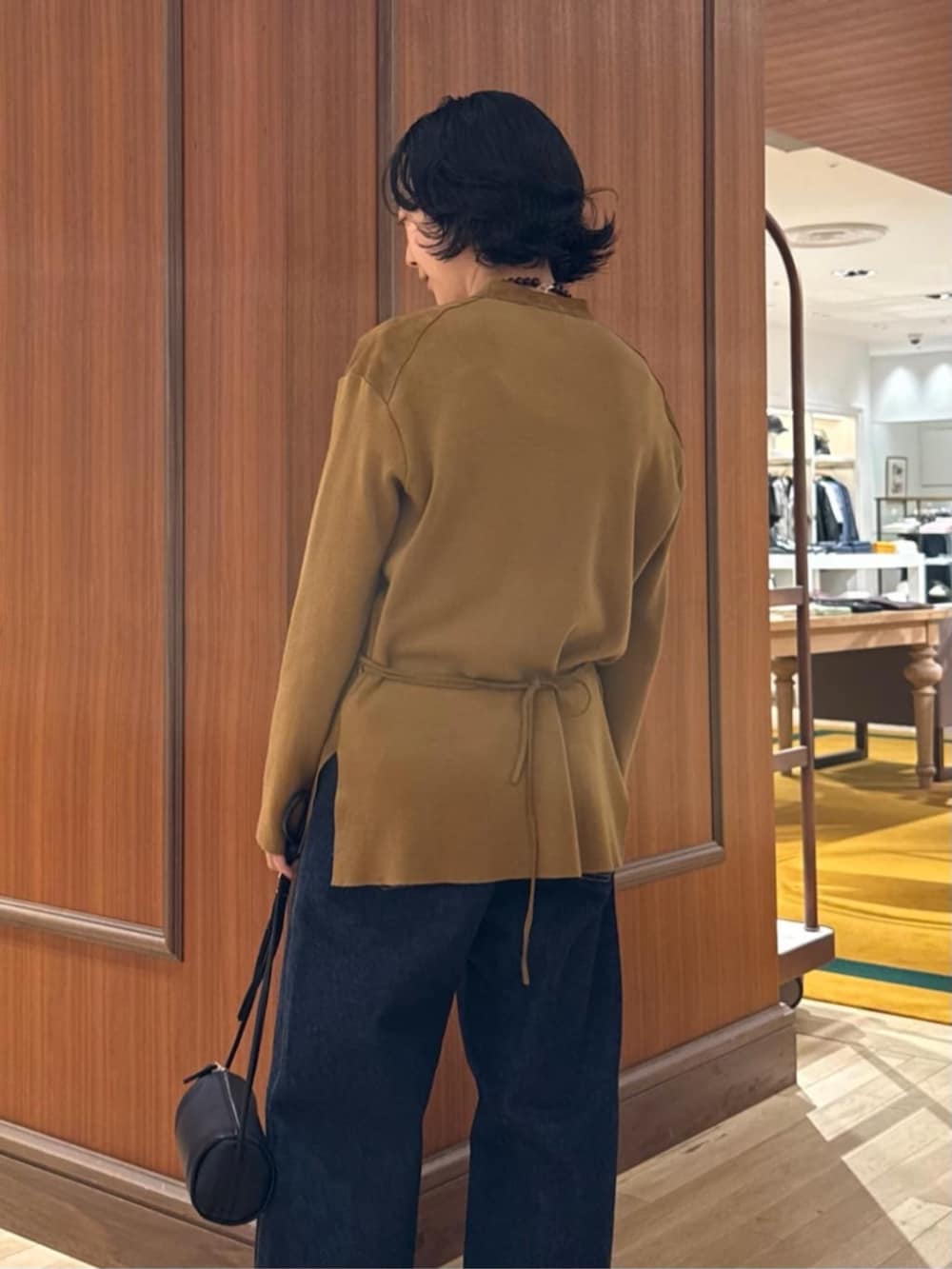 イエロー系のその他アウター、ホワイト系のキャミソール、ブルー系のデニムパンツを着用したレディースの秋コーディネートの3枚目の写真
