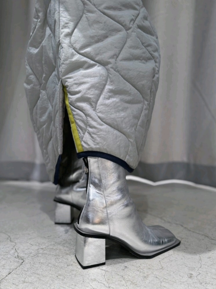 グレー系のスウェット、グレー系のスカート、シルバー系のブーツを着用したレディースの冬コーディネートの9枚目の写真