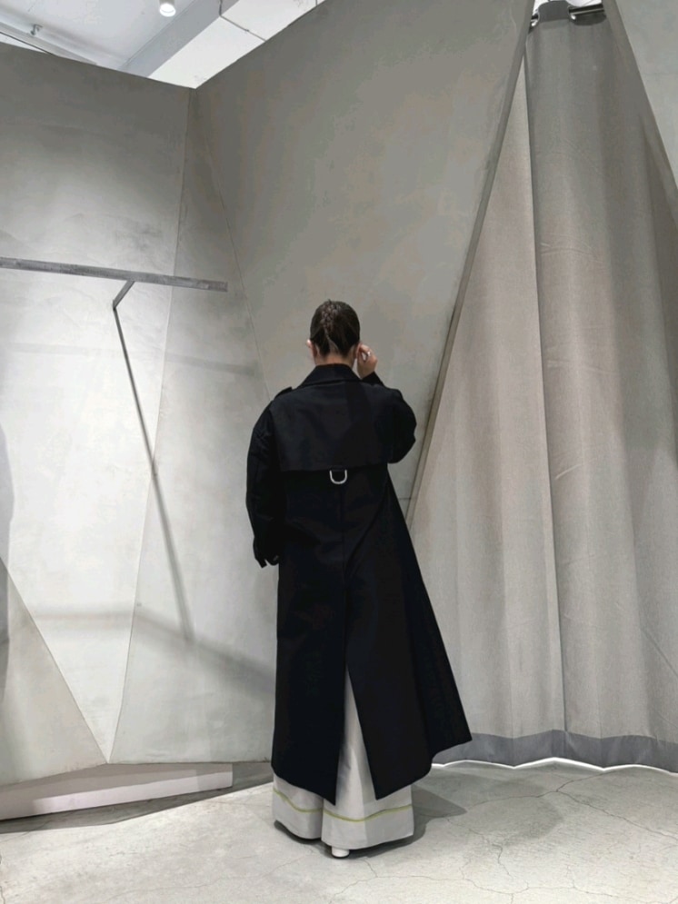 ブラック系のトレンチコート、グレー系のその他パンツ、ブラック系のパンプスを着用したレディースの春コーディネートの2枚目の写真