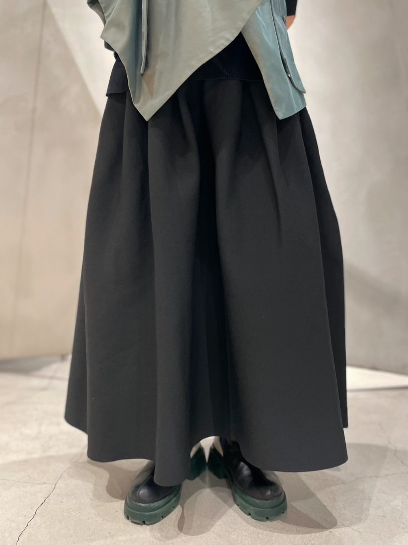 ブラック系のニット/セーター、グリーン系のキャミソール、ブラック系のスカートを着用したレディースの冬コーディネートの7枚目の写真