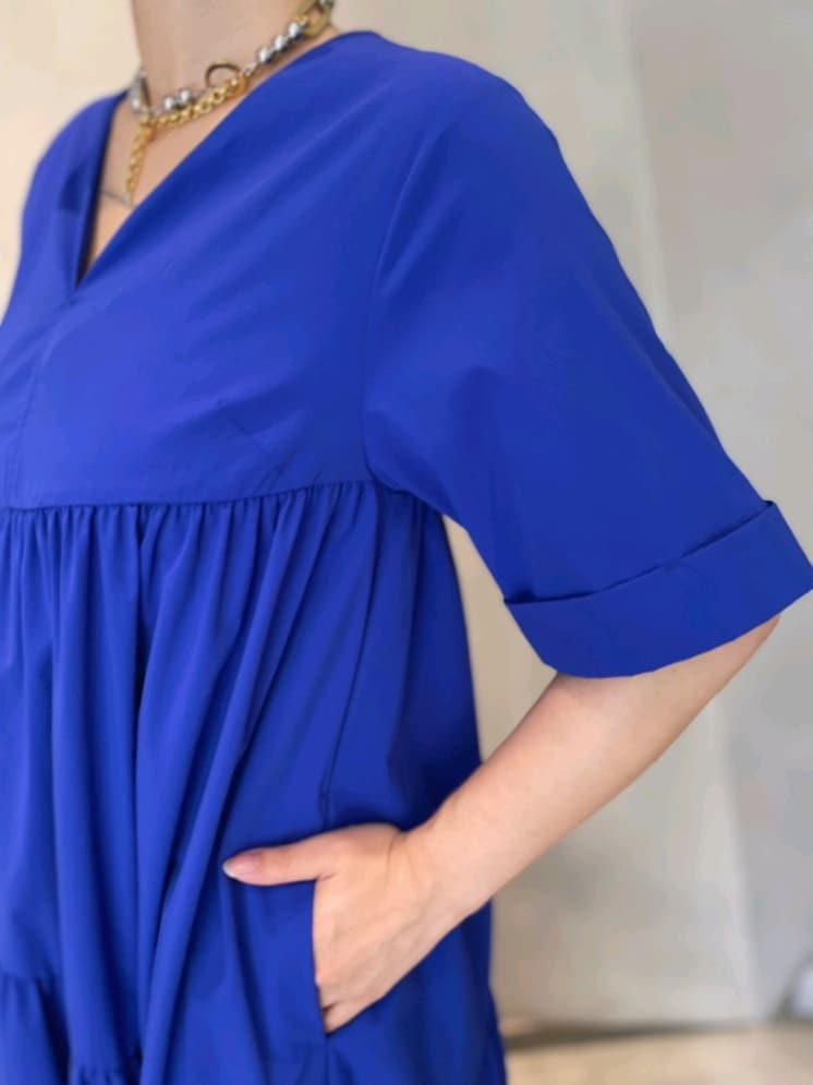 ブルー系のワンピース、ブラック系のサンダル、シルバー系のネックレスを着用したレディースの夏コーディネートの4枚目の写真