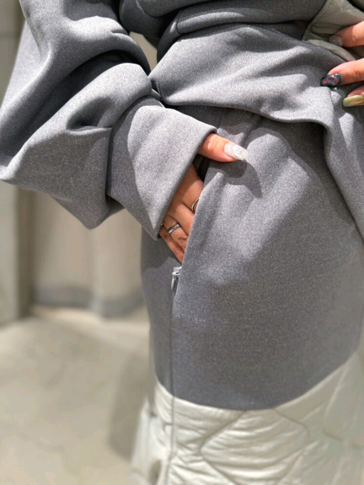 グレー系のスウェット、グレー系のスカート、シルバー系のブーツを着用したレディースの冬コーディネートの4枚目の写真