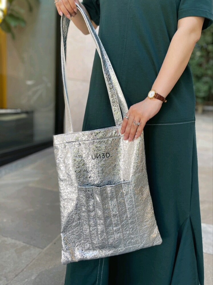 グリーン系のワンピース、ブラック系のサンダル、シルバー系のトートバッグを着用したレディースの夏コーディネートの7枚目の写真