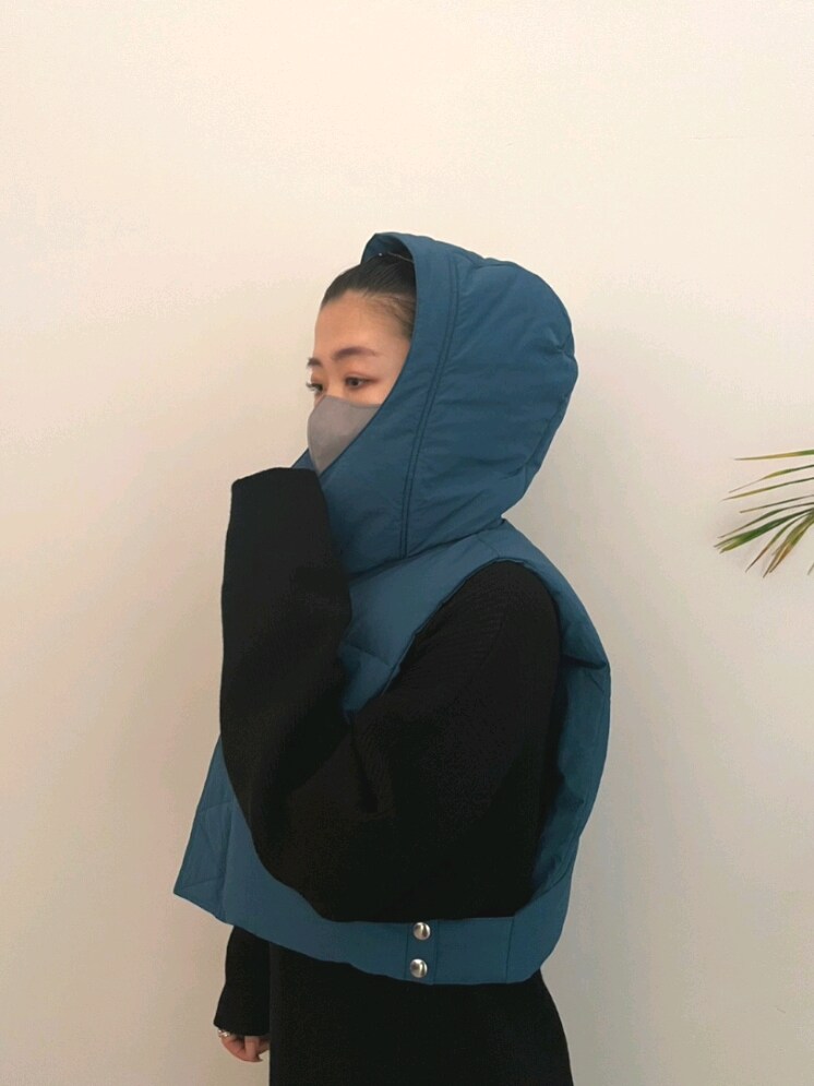 ブルー系のダウンベスト、ブラック系のワンピース、ブラック系のブーツを着用したレディースの夏コーディネートの4枚目の写真