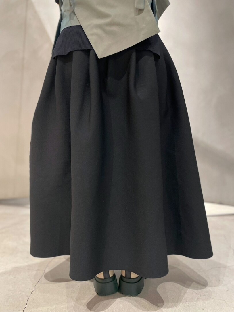 ブラック系のニット/セーター、グリーン系のキャミソール、ブラック系のスカートを着用したレディースの冬コーディネートの8枚目の写真