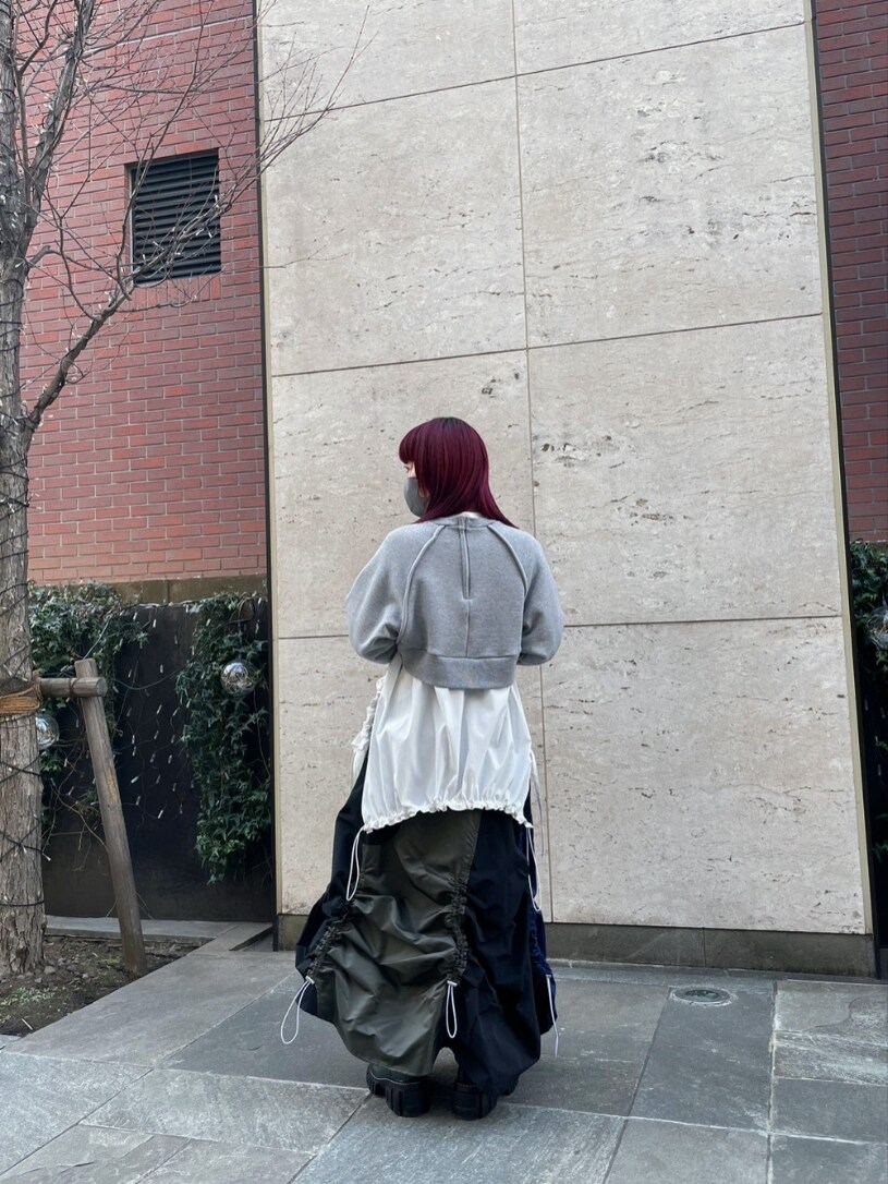 グレー系のスウェット、ホワイト系のシャツ/ブラウス、ブラック系のスカートを着用したレディースの冬コーディネートの2枚目の写真