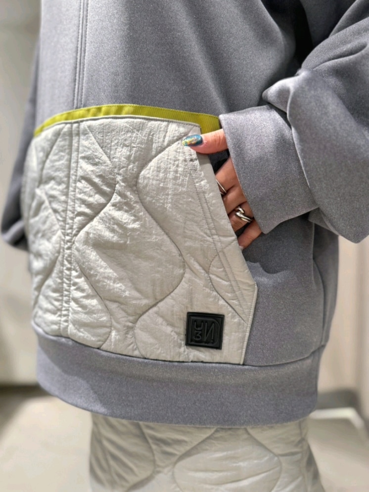 グレー系のスウェット、グレー系のスカート、シルバー系のブーツを着用したレディースの冬コーディネートの3枚目の写真