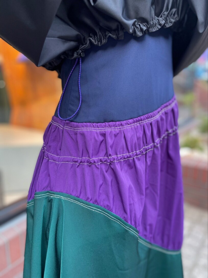 ブラック系のTシャツ/カットソー、パープル系のワンピース、ブラック系のブーツを着用したレディースの春コーディネートの7枚目の写真