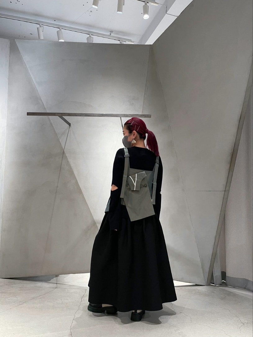 ブラック系のニット/セーター、グリーン系のキャミソール、ブラック系のスカートを着用したレディースの冬コーディネートの2枚目の写真