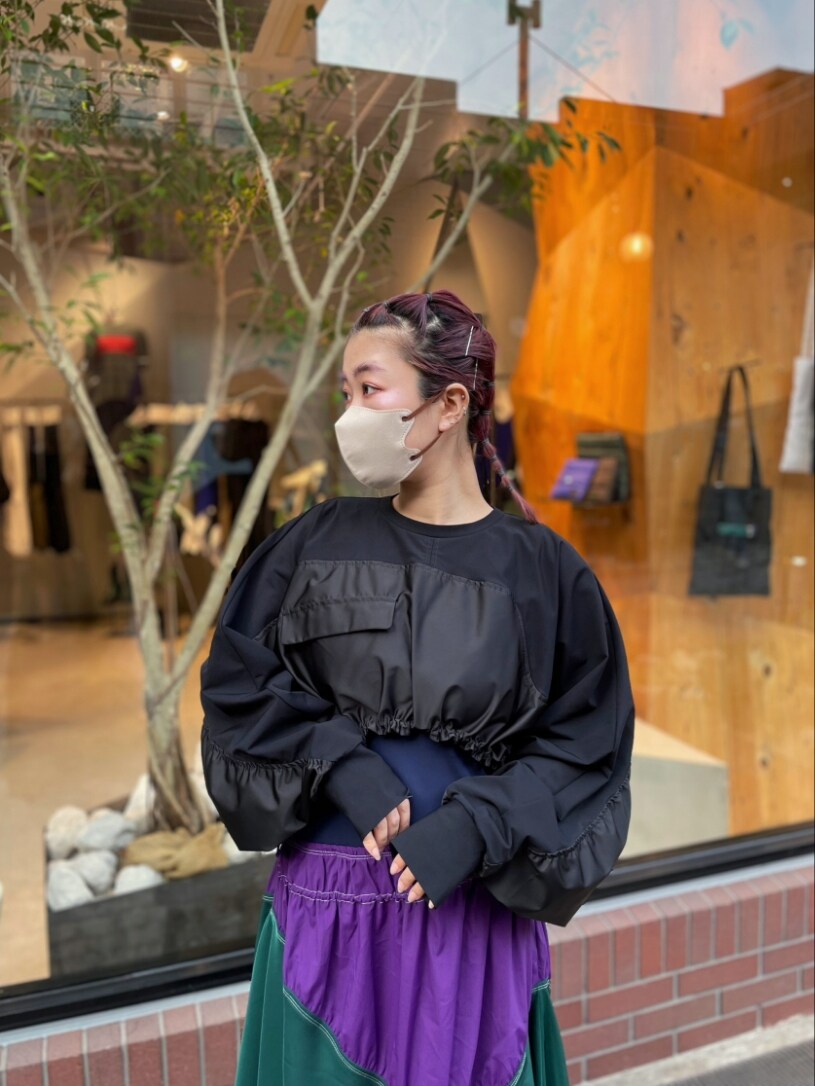 ブラック系のTシャツ/カットソー、パープル系のワンピース、ブラック系のブーツを着用したレディースの春コーディネートの3枚目の写真