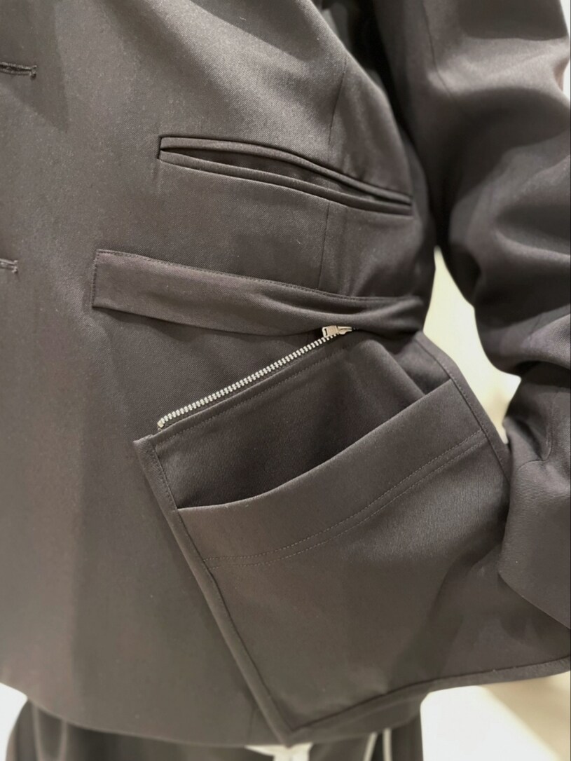 ブラック系のテーラードジャケット、ホワイト系のシャツ/ブラウス、ブラック系のキャミソールを着用したレディースの冬コーディネートの5枚目の写真