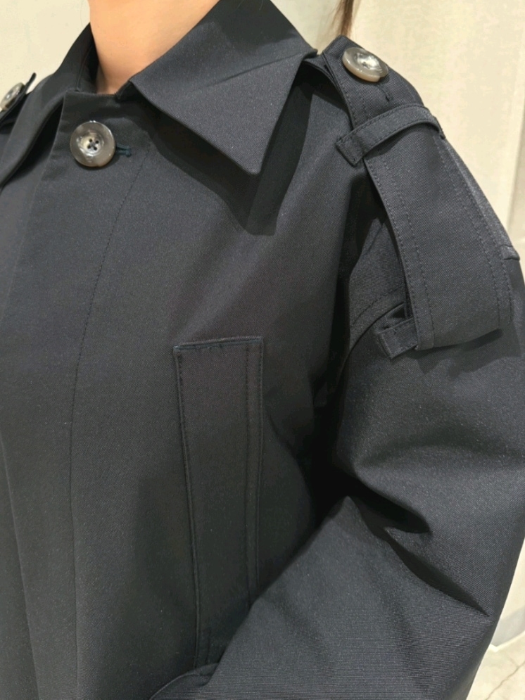 ブラック系のトレンチコート、グレー系のその他パンツ、ブラック系のパンプスを着用したレディースの春コーディネートの4枚目の写真