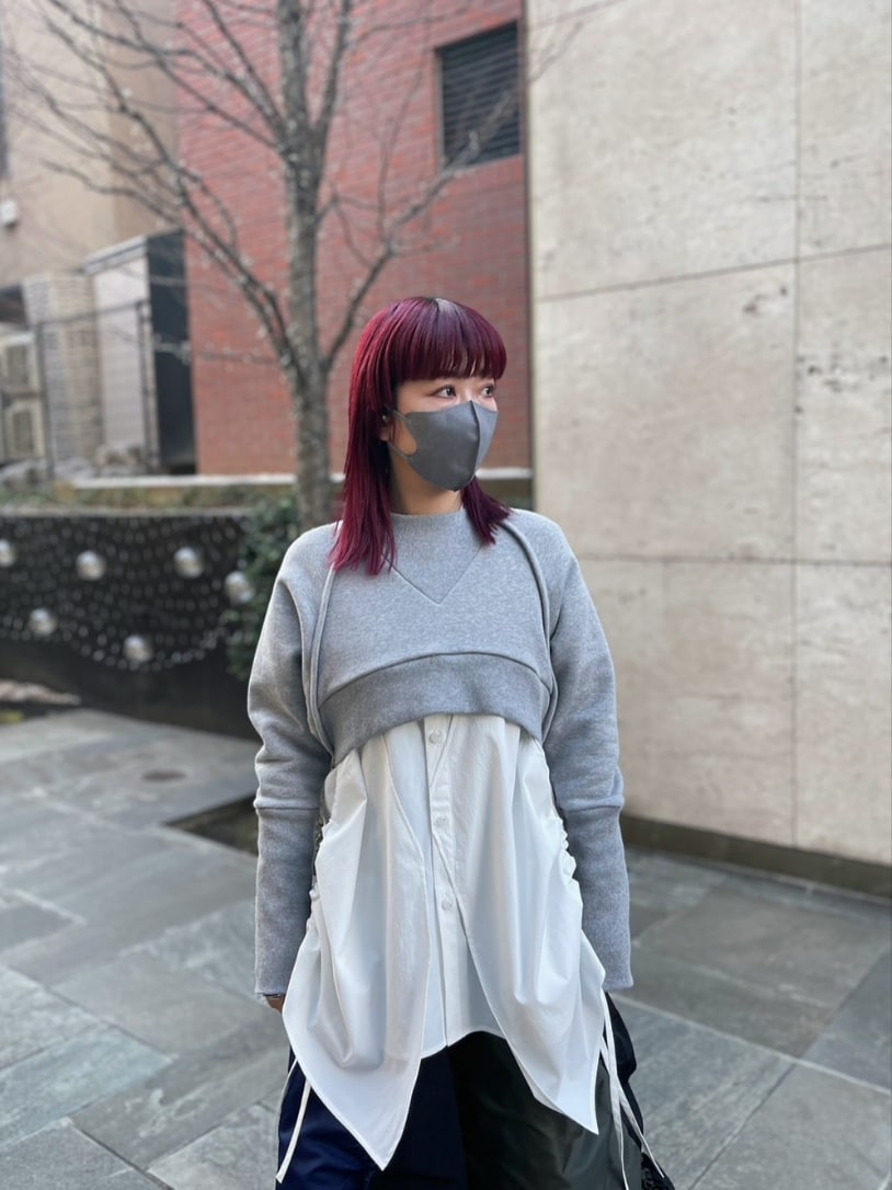 グレー系のスウェット、ホワイト系のシャツ/ブラウス、ブラック系のスカートを着用したレディースの冬コーディネートの3枚目の写真