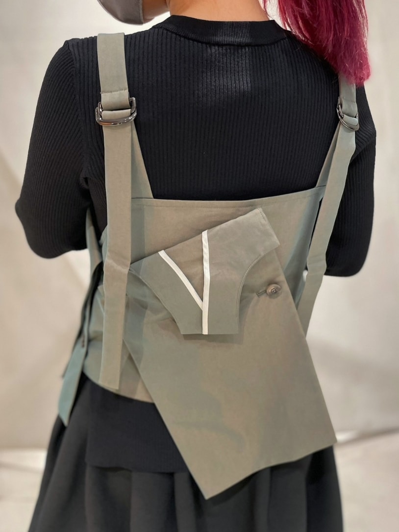 ブラック系のニット/セーター、グリーン系のキャミソール、ブラック系のスカートを着用したレディースの冬コーディネートの5枚目の写真