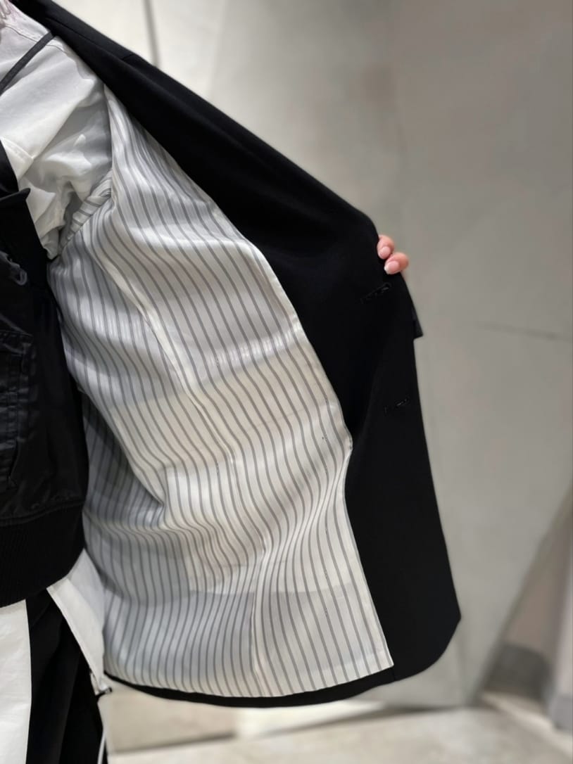 ブラック系のテーラードジャケット、ホワイト系のシャツ/ブラウス、ブラック系のキャミソールを着用したレディースの冬コーディネートの7枚目の写真