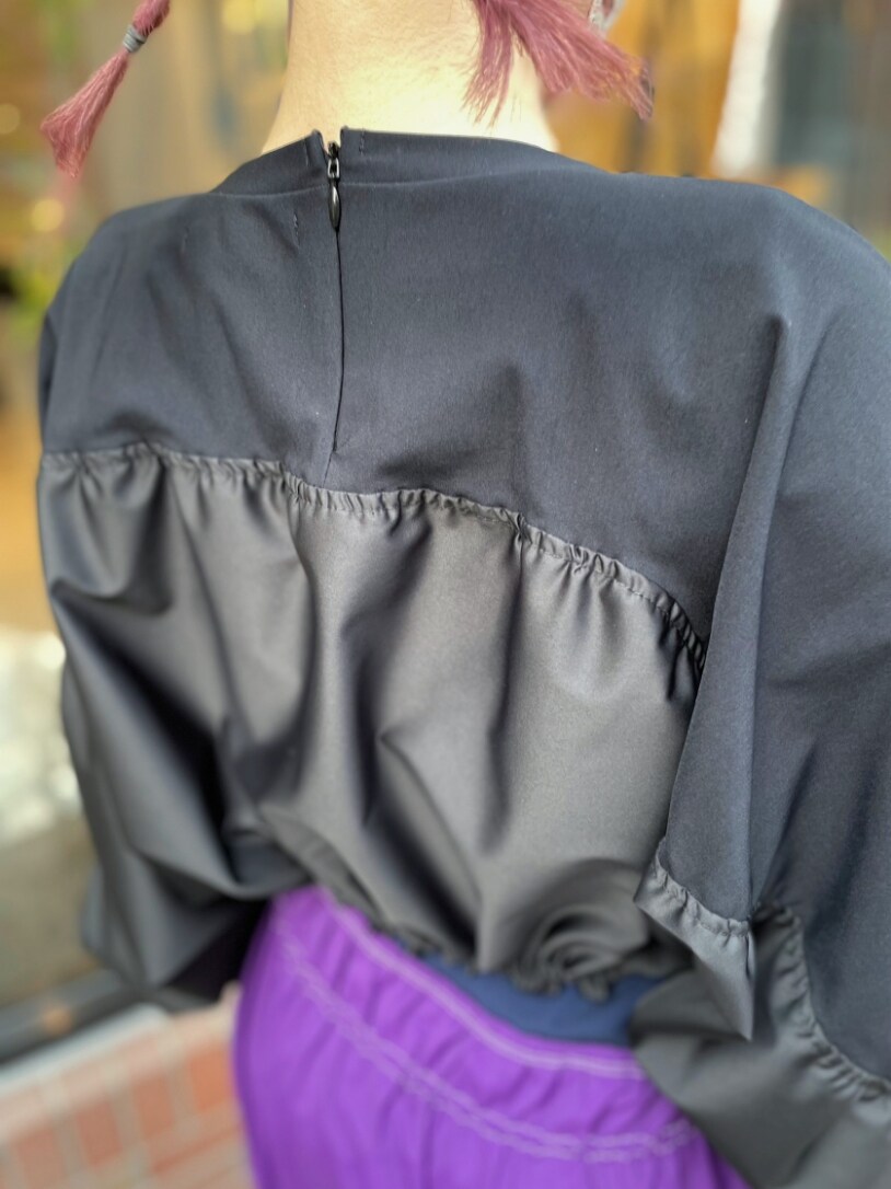 ブラック系のTシャツ/カットソー、パープル系のワンピース、ブラック系のブーツを着用したレディースの春コーディネートの5枚目の写真