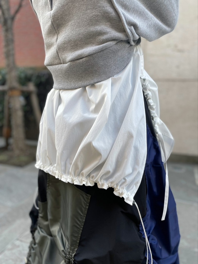 グレー系のスウェット、ホワイト系のシャツ/ブラウス、ブラック系のスカートを着用したレディースの冬コーディネートの7枚目の写真