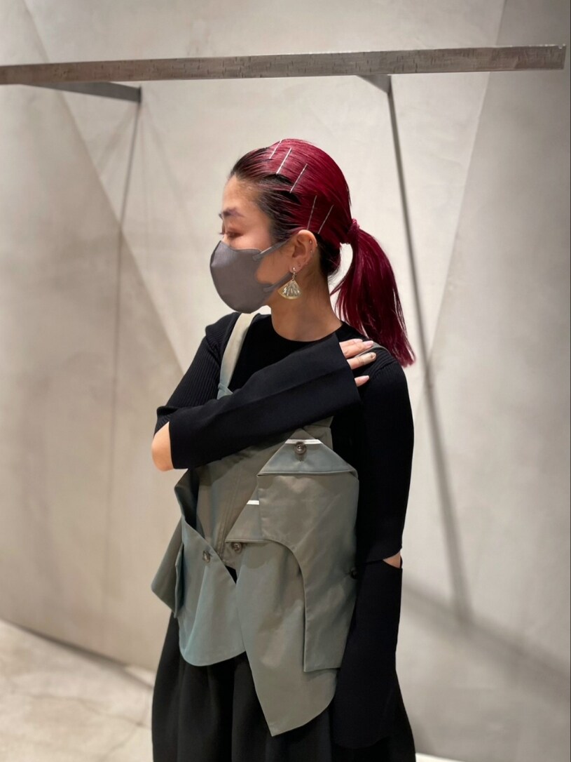 ブラック系のニット/セーター、グリーン系のキャミソール、ブラック系のスカートを着用したレディースの冬コーディネートの3枚目の写真