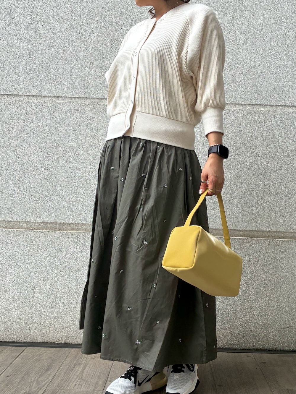 グリーン系のスカート、ホワイト系のカーディガン/ボレロ、イエロー系のトートバッグを着用したレディースの春コーディネートの3枚目の写真