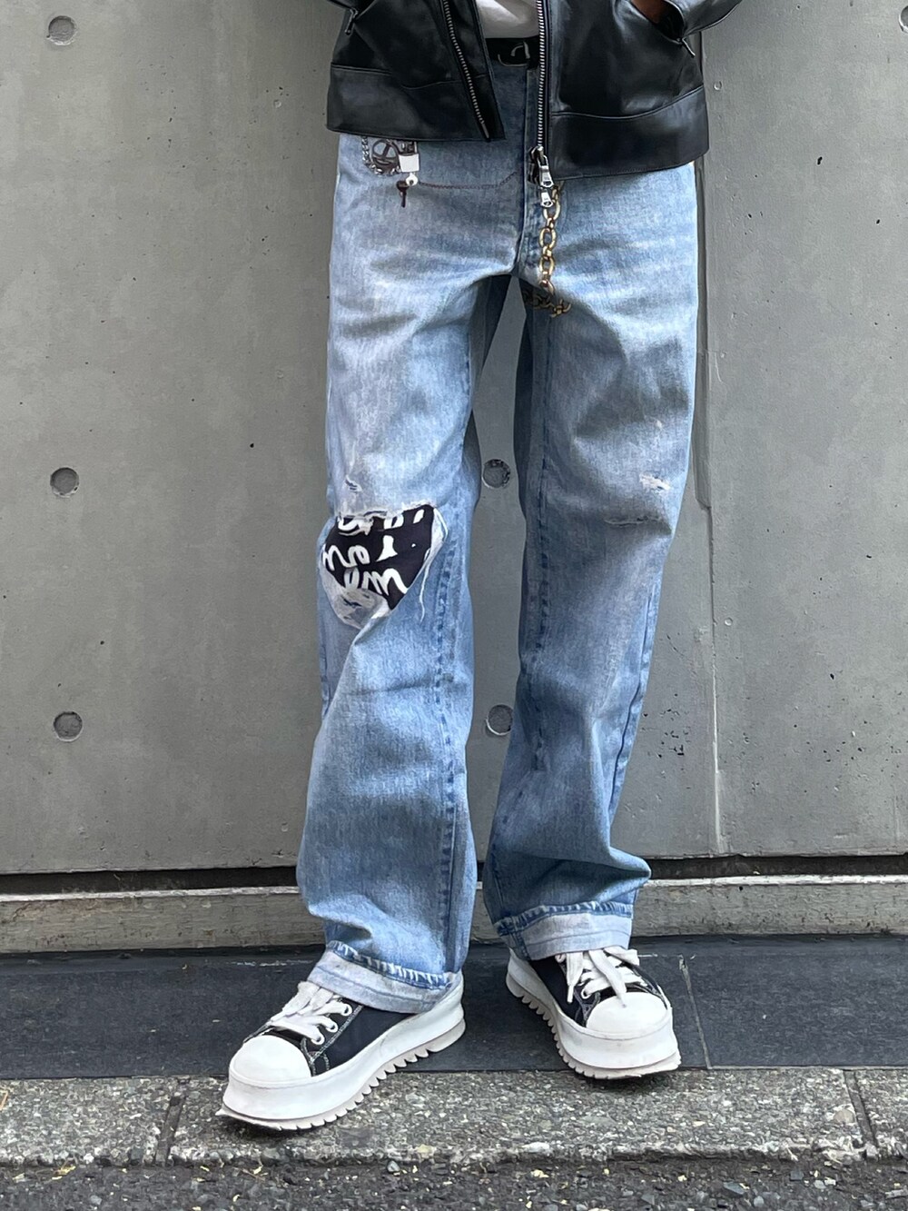 ブラック系のライダースジャケット、ブルー系のデニムパンツ、ブラック系のスニーカーを着用したメンズの夏コーディネートの3枚目の写真