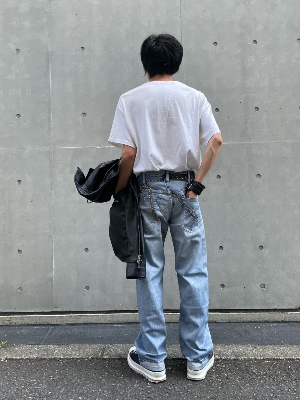 ブラック系のライダースジャケット、ブルー系のデニムパンツ、ブラック系のスニーカーを着用したメンズの夏コーディネートの5枚目の写真