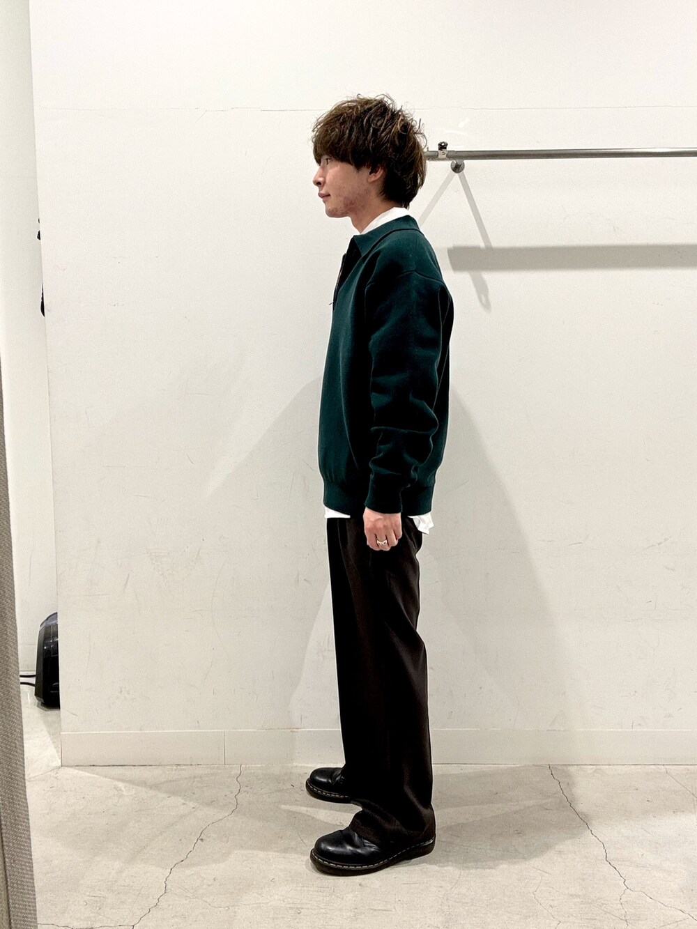 グリーン系のニット/セーター、レッド系のネクタイ、グレー系のその他パンツを着用したメンズの秋コーディネートの2枚目の写真