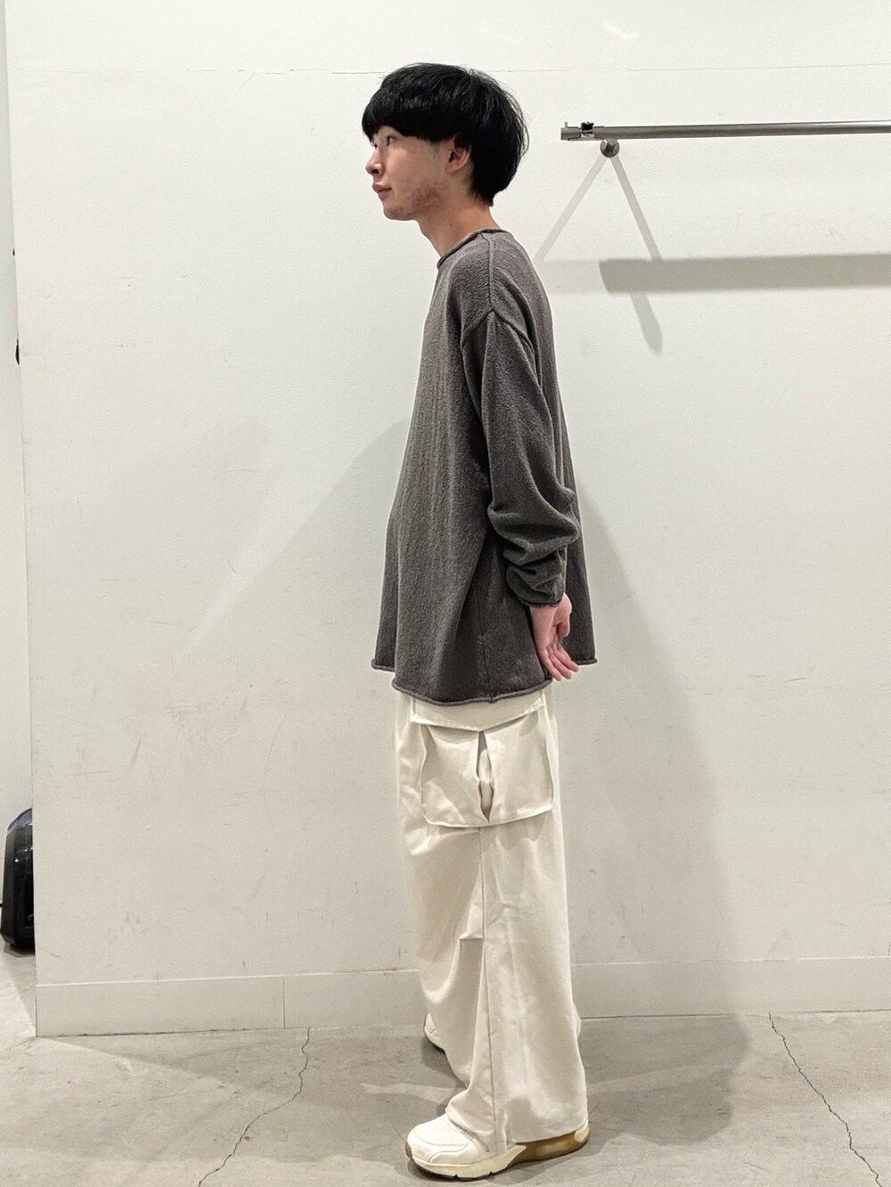 グレー系のニット/セーター、ホワイト系のその他パンツを着用したメンズの秋コーディネートの2枚目の写真