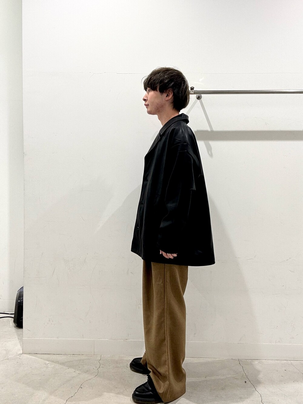 ブラック系のその他アウター、ホワイト系のTシャツ/カットソー、ブラウン系のその他パンツを着用したメンズの秋コーディネートの2枚目の写真