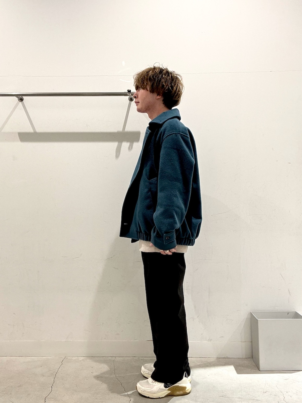 ブルー系のブルゾン、ベージュ系のニット/セーター、グレー系のその他パンツを着用したメンズの冬コーディネートの2枚目の写真