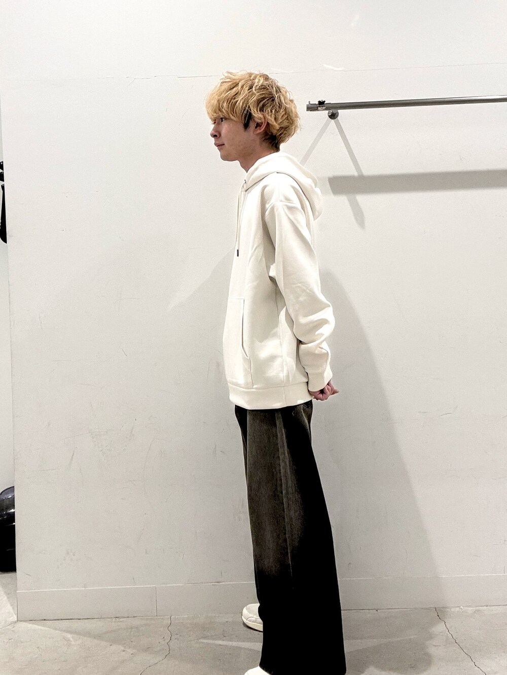 ホワイト系のパーカー、ブラック系のデニムパンツを着用したメンズの秋コーディネートの2枚目の写真