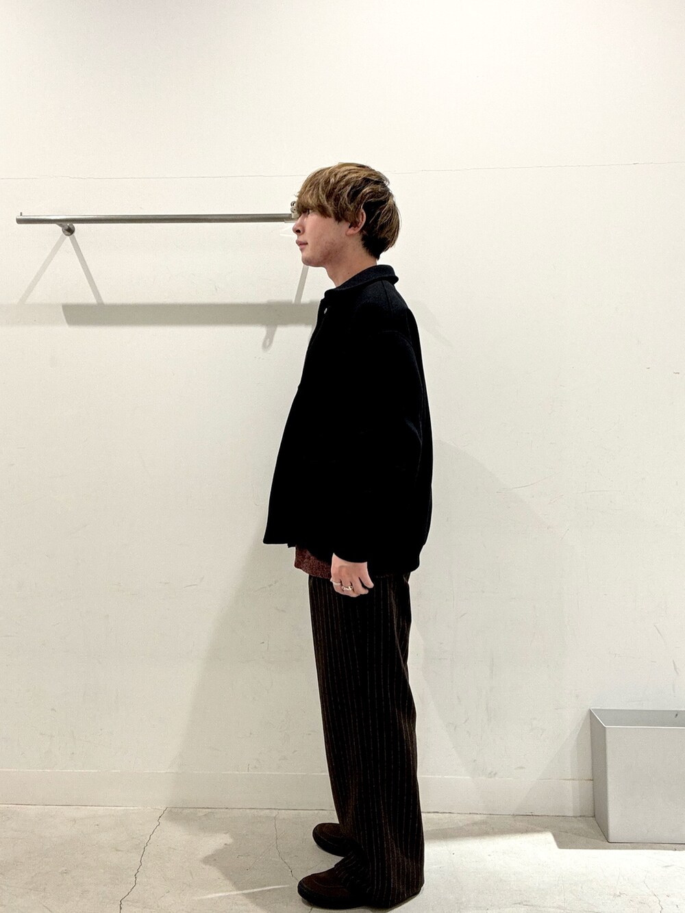 ブラック系のブルゾン、ブラウン系のその他パンツ、ブラウン系のニット/セーターを着用したメンズの冬コーディネートの2枚目の写真