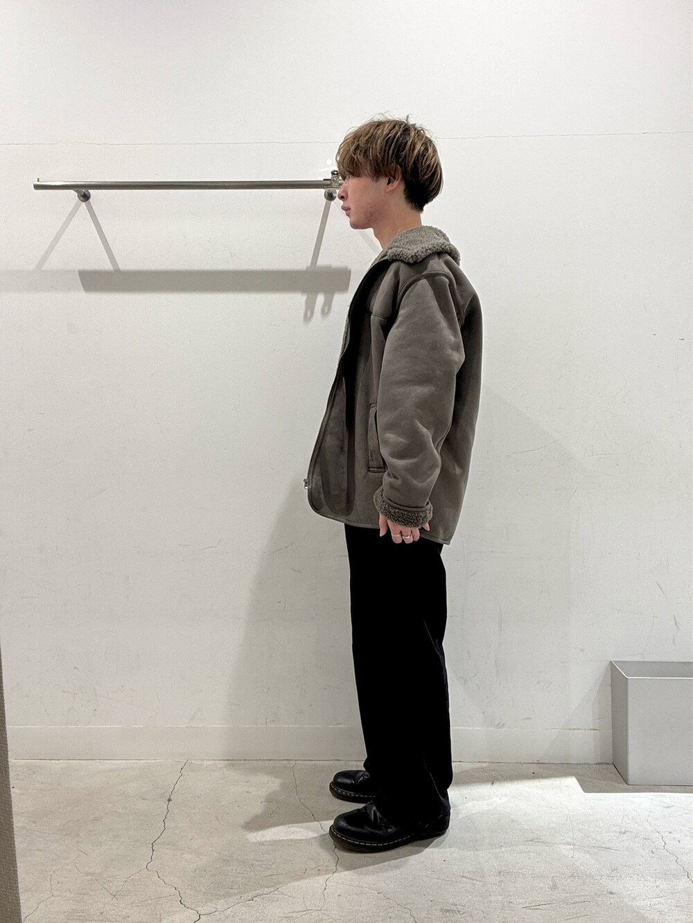 グレー系のブルゾン、ブラウン系のニット/セーター、ブラック系のその他パンツを着用したメンズの秋コーディネートの2枚目の写真