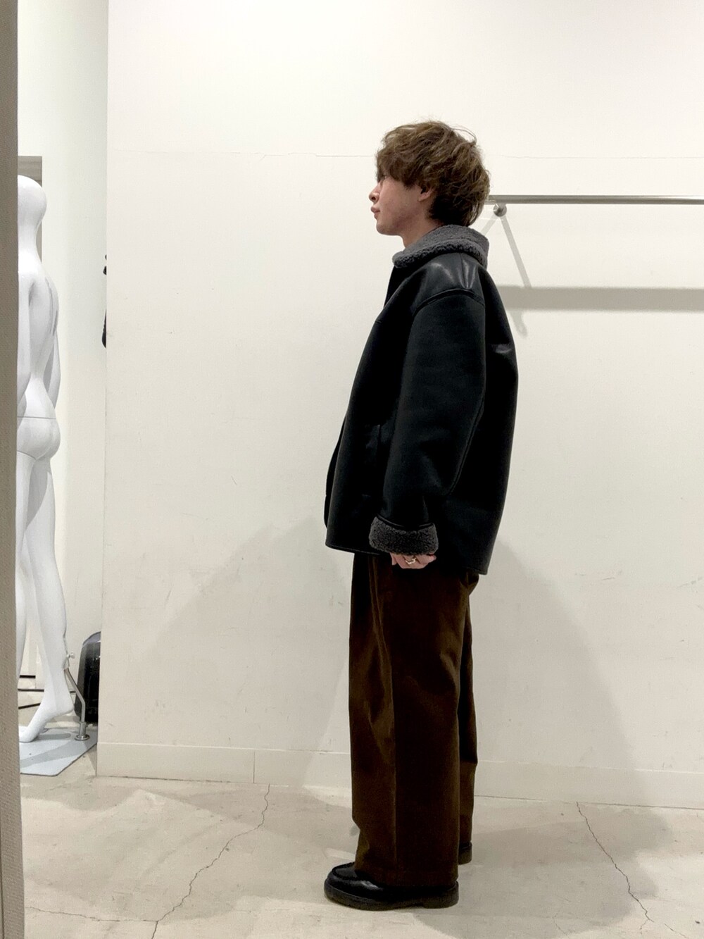 ブラック系のブルゾン、ブラウン系のその他パンツを着用したメンズの秋コーディネートの2枚目の写真