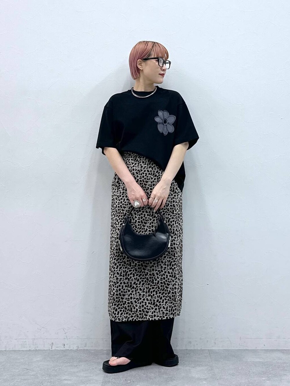 ブラック系のスラックス、ブラック系のTシャツ/カットソー、ベージュ系のスカートを着用したレディースの春コーディネートの3枚目の写真