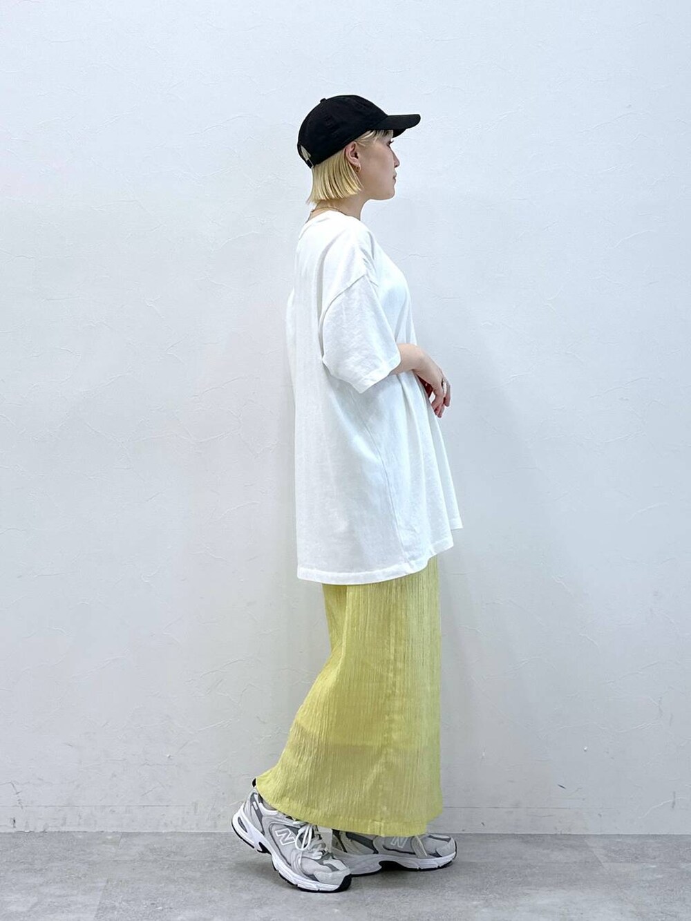ホワイト系のTシャツ/カットソー、イエロー系のスカートを着用したレディースの夏コーディネートの2枚目の写真