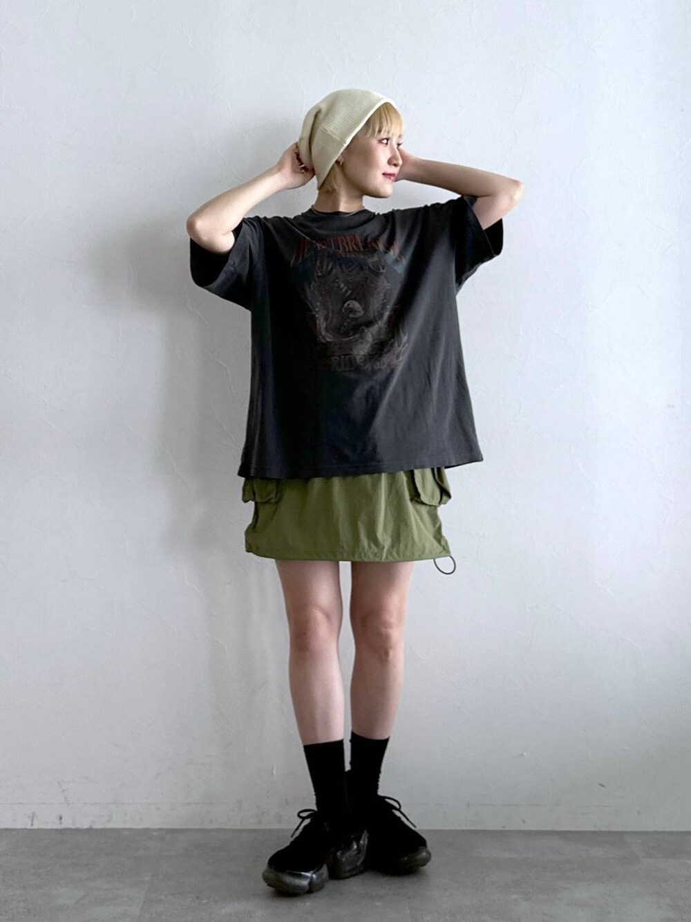 グリーン系のスカート、ブラック系のTシャツ/カットソーを着用したレディースの夏コーディネートの3枚目の写真