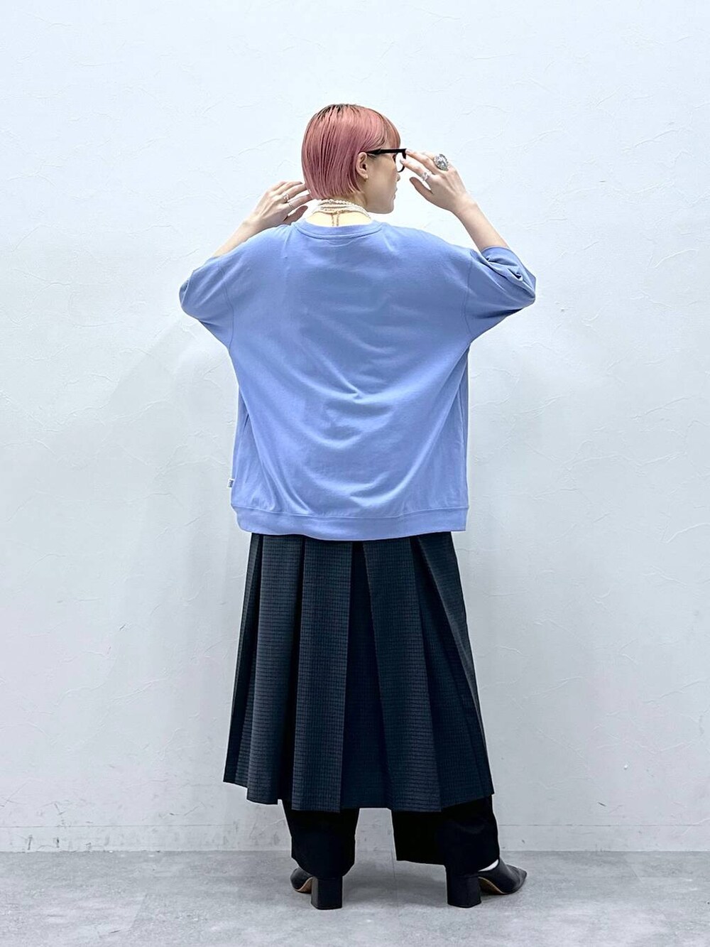 ブラック系のスラックス、ブルー系のTシャツ/カットソー、グレー系のスカートを着用したレディースの春コーディネートの6枚目の写真