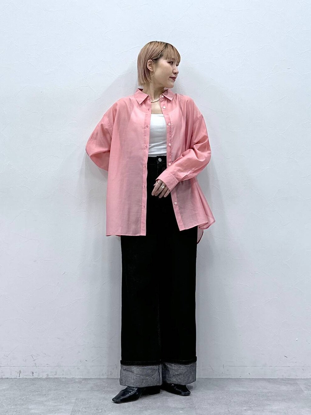 ブラック系のデニムパンツ、ピンク系のシャツ/ブラウスを着用したレディースの春コーディネートの3枚目の写真