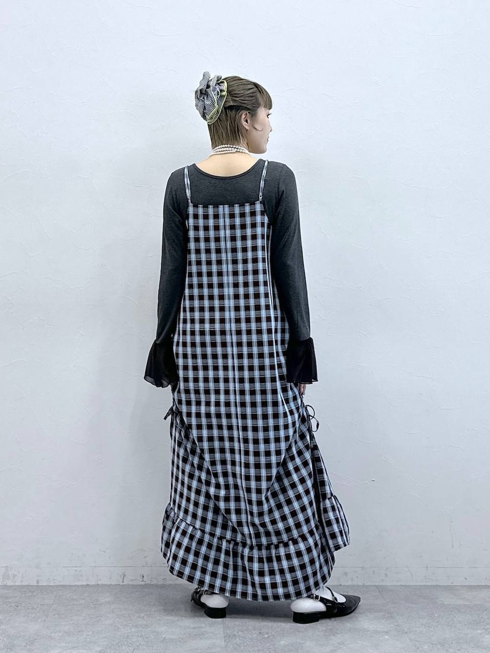 ブラック系のパンプス、ブラウン系のワンピース、グレー系のTシャツ/カットソーを着用したレディースの冬コーディネートの6枚目の写真