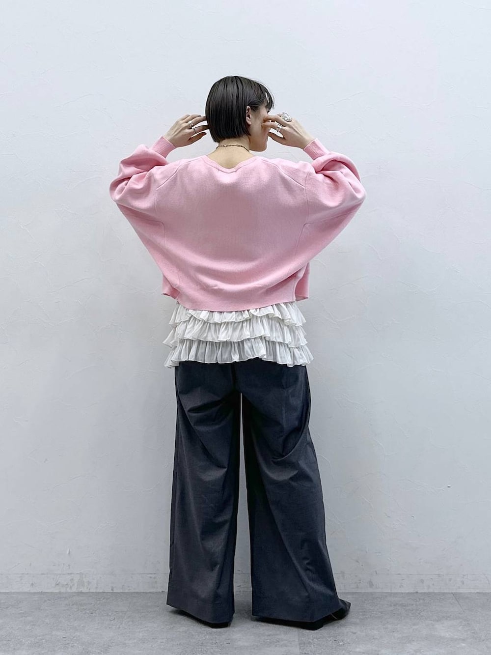 ホワイト系のキャミソール、ピンク系のカーディガン/ボレロ、グレー系のスラックスを着用したレディースの春コーディネートの6枚目の写真