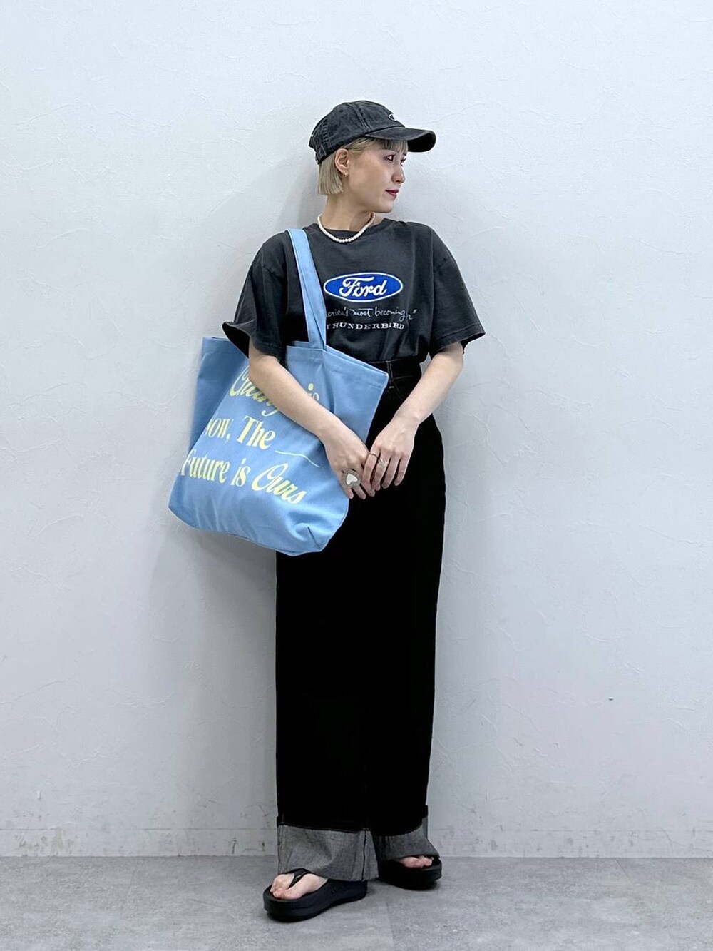 ブラック系のTシャツ/カットソー、ブラック系のデニムパンツ、ピンク系のトートバッグを着用したレディースの夏コーディネートの2枚目の写真