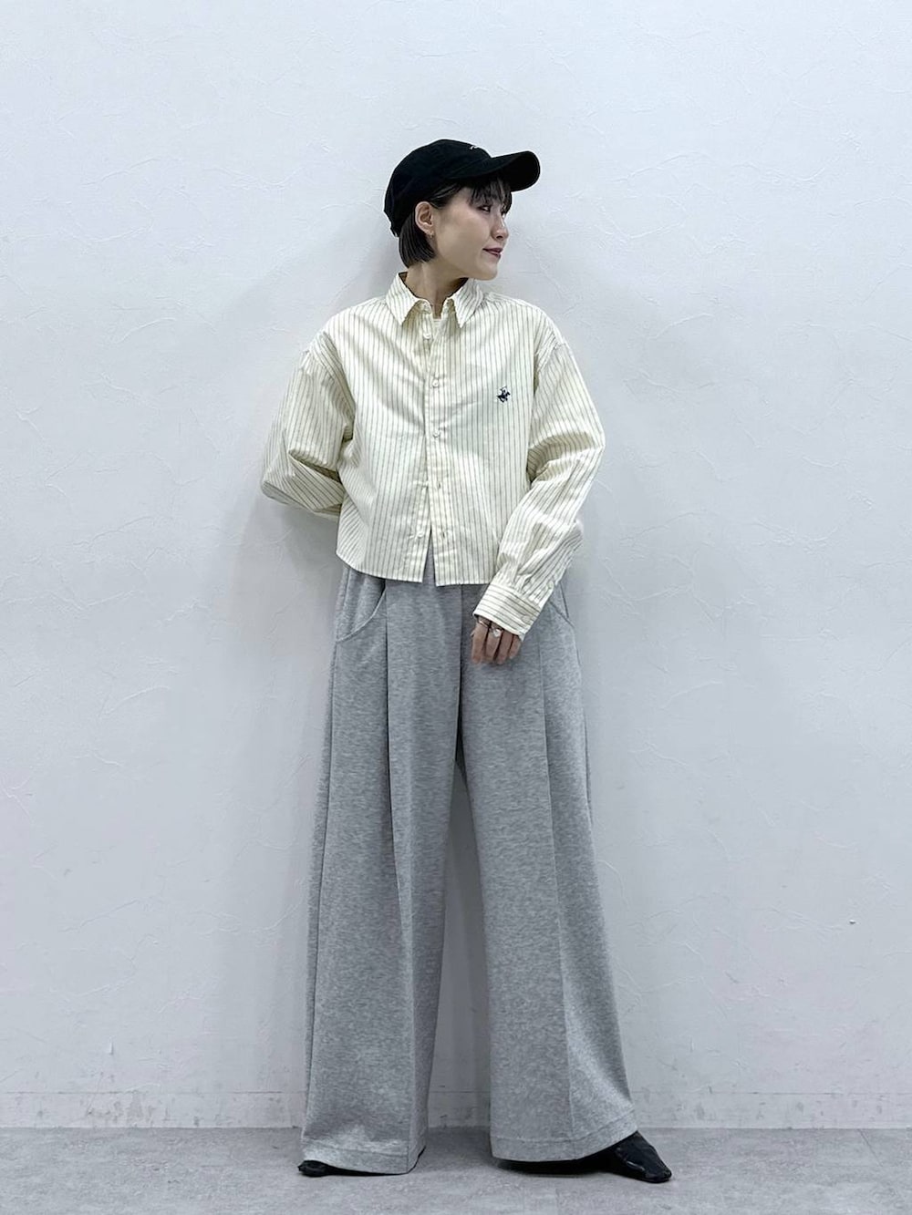 イエロー系のシャツ/ブラウス、グレー系のスウェットパンツ、ブラック系のキャップを着用したレディースの春コーディネートの3枚目の写真