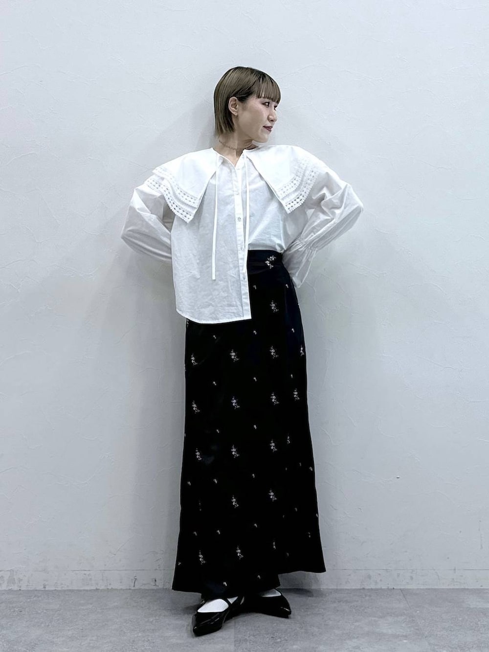 ホワイト系のシャツ/ブラウス、ブラック系のパンプス、ブラック系のスカートを着用したレディースの冬コーディネートの2枚目の写真