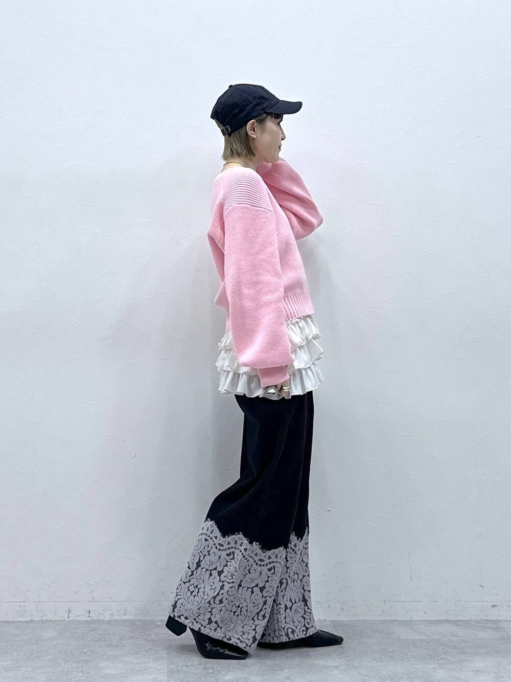 ホワイト系のキャミソール、ピンク系のニット/セーター、ブラック系のデニムパンツを着用したレディースの冬コーディネートの5枚目の写真