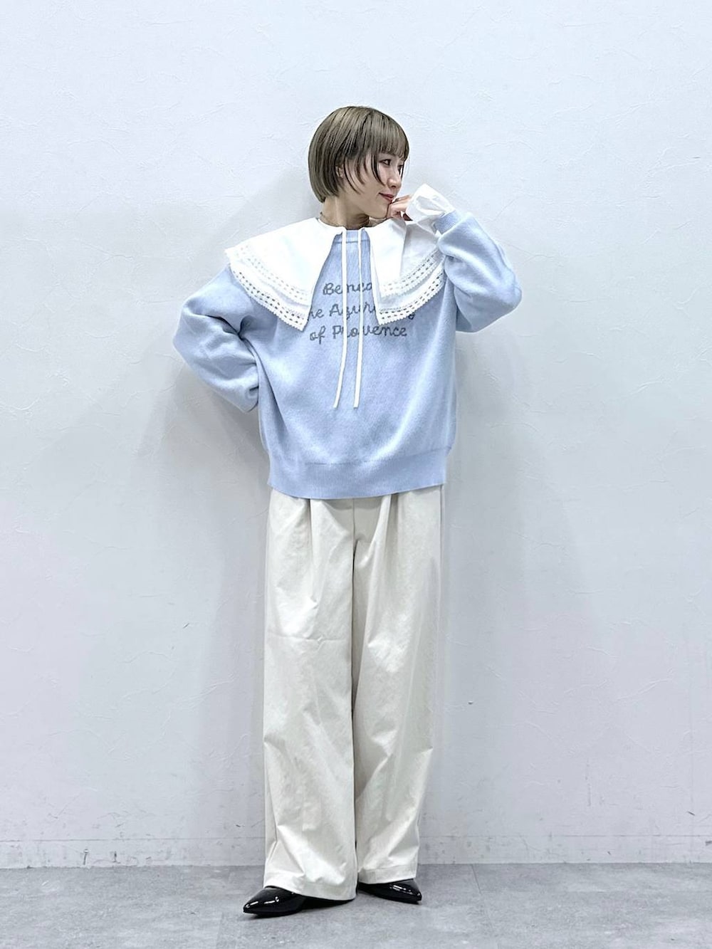 ホワイト系のチノパンツ、ホワイト系のシャツ/ブラウス、ブルー系のニット/セーターを着用したレディースの冬コーディネートの3枚目の写真