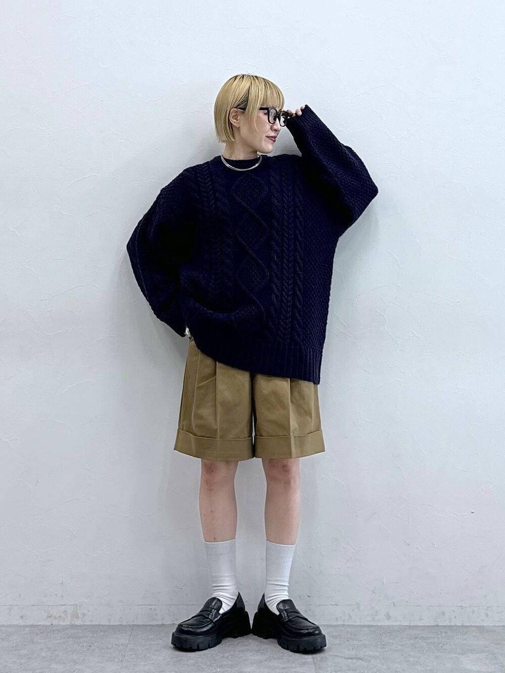 ブラック系のローファー、ブラウン系のチノパンツ、ブルー系のニット/セーターを着用したレディースの秋コーディネートの3枚目の写真