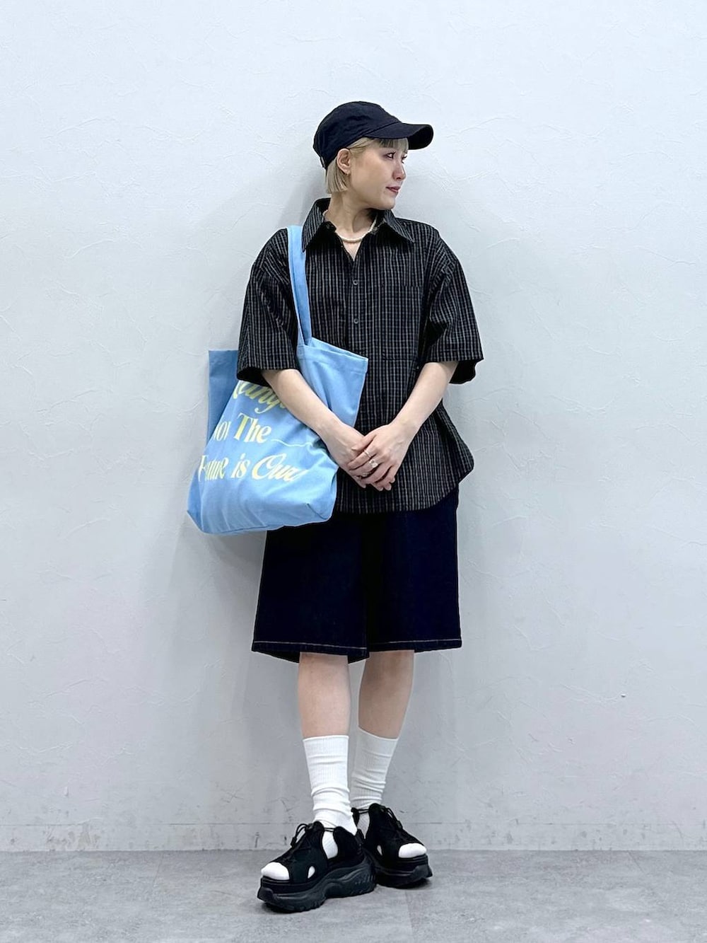 ブラック系のサンダル、ブルー系のデニムパンツ、ピンク系のトートバッグを着用したレディースの夏コーディネートの4枚目の写真