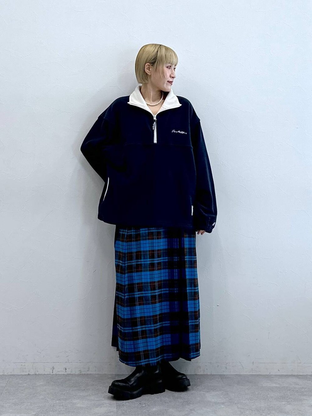 ブルー系のスウェット、ブラック系のブーツ、ブルー系のスカートを着用したレディースの秋コーディネートの3枚目の写真